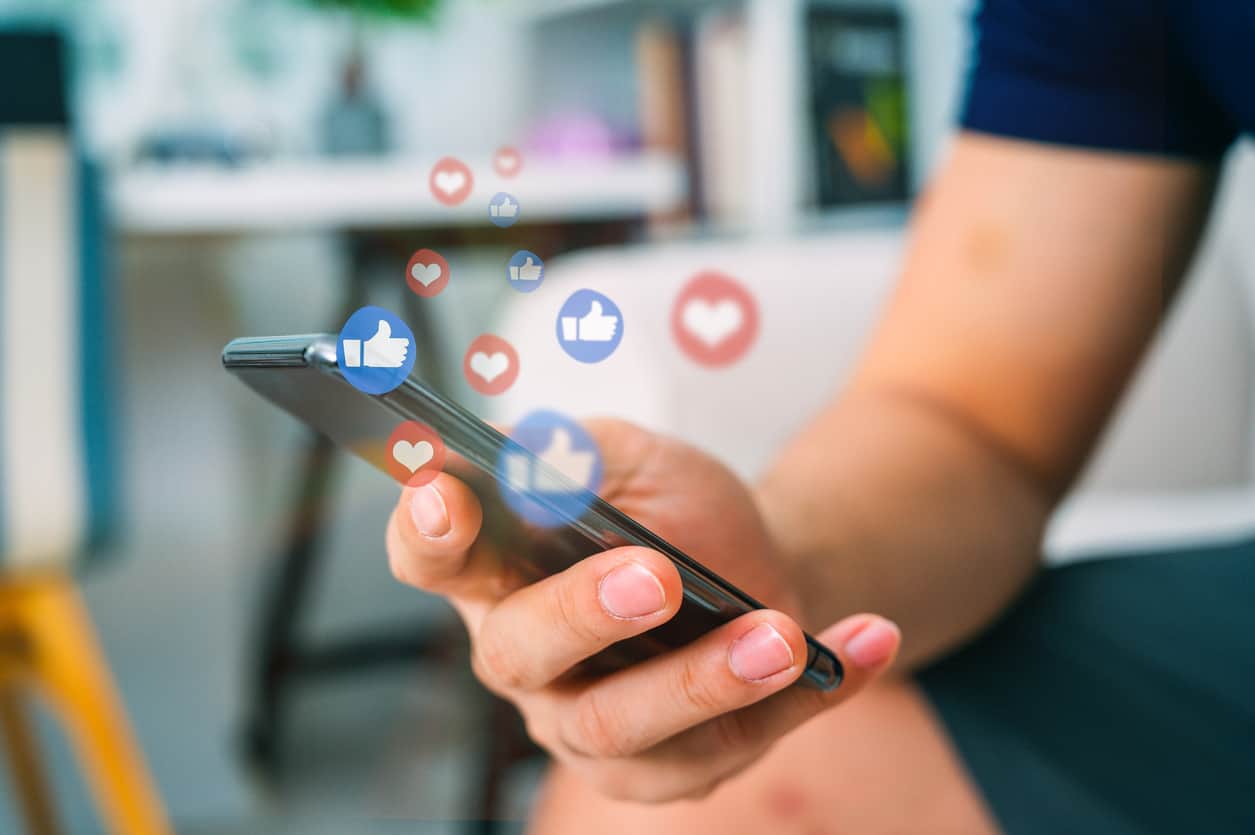 Hand using smart phone with Social media concept social media likes
